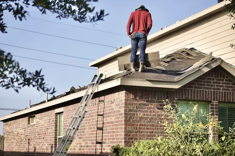 Professional roofer working on a residential roof in Creek View